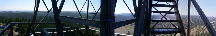 [This last part is the view through the tower structure starting from the railing on the left (same railing as prior view) and continuing to the stairwell on the right. The right side railing of the stairwell is the same metal as viewed on the leftmost side of the first view.]